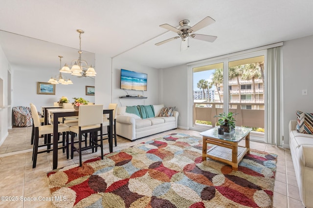 living area featuring light tile patterned flooring, ceiling fan, a chandelier, and baseboards