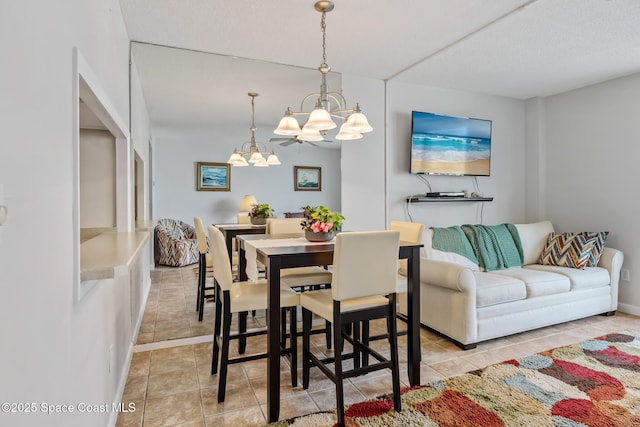dining area with a chandelier and light tile patterned floors