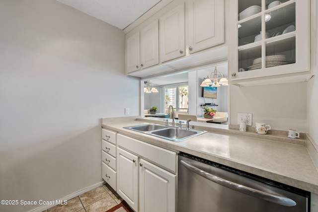 kitchen featuring stainless steel dishwasher, a sink, white cabinets, a chandelier, and glass insert cabinets