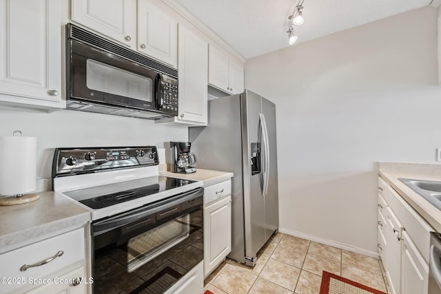 kitchen with appliances with stainless steel finishes, light countertops, white cabinetry, baseboards, and light tile patterned flooring