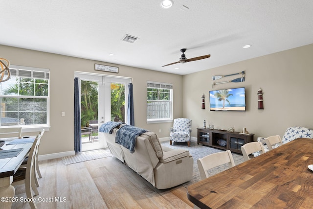 living room with baseboards, light wood finished floors, a ceiling fan, and recessed lighting