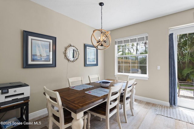 dining room featuring a chandelier, baseboards, and healthy amount of natural light