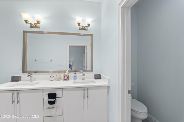 bathroom featuring double vanity and toilet