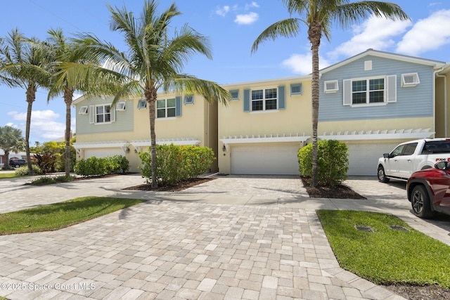 view of property featuring an attached garage and decorative driveway