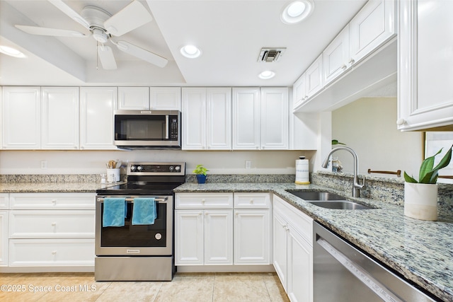 kitchen with appliances with stainless steel finishes, a sink, recessed lighting, white cabinets, and light tile patterned flooring