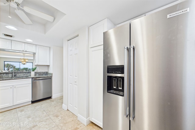 kitchen with appliances with stainless steel finishes, a sink, white cabinetry, light tile patterned floors, and ceiling fan