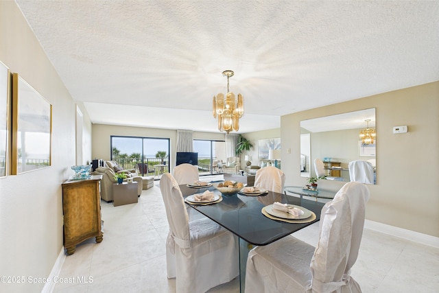 dining room featuring a chandelier, a textured ceiling, baseboards, and light tile patterned floors