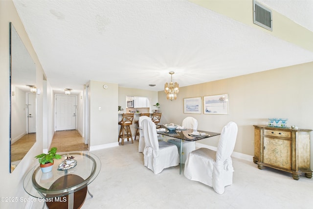 dining area with a chandelier and baseboards