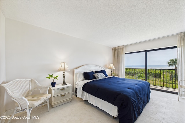 bedroom with access to outside and a textured ceiling