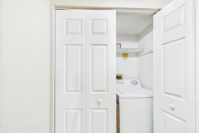 clothes washing area with washer / dryer and a textured ceiling