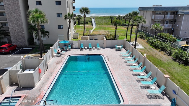 community pool featuring a water view and fence