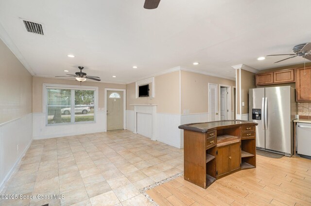 1751 5th Ct, Vero Beach, FL 32960 - kitchen featuring a ceiling fan, stainless steel appliances, ornamental molding, wainscoting, and brown cabinets