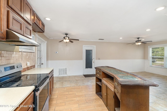 1751 5th Ct, Vero Beach, FL 32960 - kitchen featuring electric stove, ceiling fan, wainscoting, under cabinet range hood, and brown cabinetry