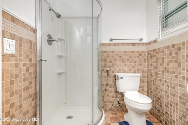 1751 5th Ct, Vero Beach, FL 32960 - bathroom with tile walls, a shower stall, toilet, and wainscoting
