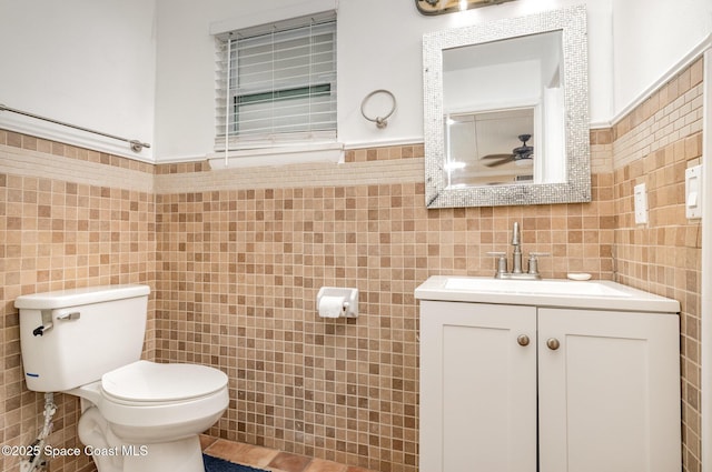 1751 5th Ct, Vero Beach, FL 32960 - bathroom featuring tile walls, toilet, vanity, and ceiling fan