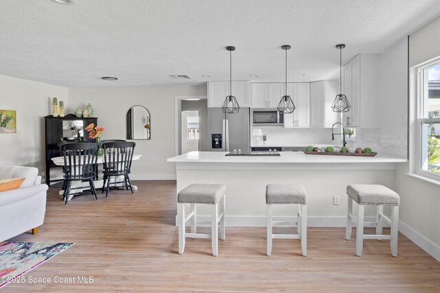 1108 Vineland St, Cocoa, FL 32927 - kitchen featuring stainless steel appliances, a breakfast bar area, light countertops, a peninsula, and plenty of natural light
