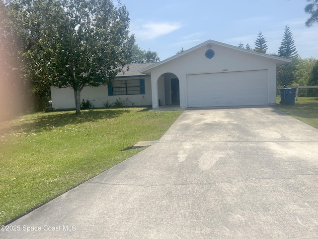 single story home featuring stucco siding, a front yard, an attached garage, and driveway