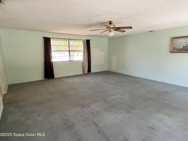 carpeted empty room with a ceiling fan, a textured ceiling, and baseboards