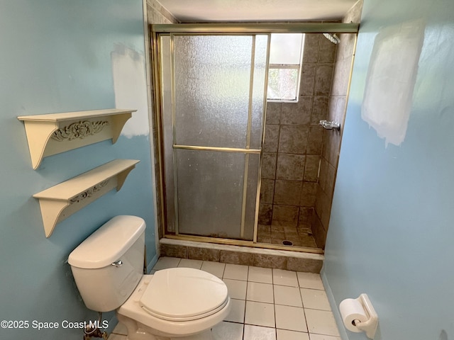 bathroom featuring a stall shower, toilet, and tile patterned floors