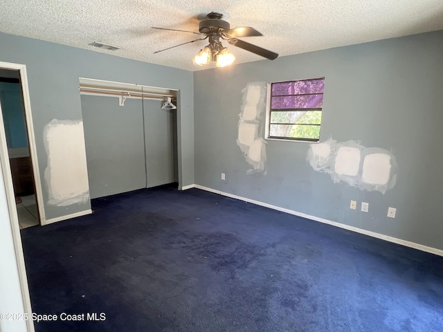 unfurnished bedroom featuring a textured ceiling, a closet, baseboards, a ceiling fan, and carpet floors