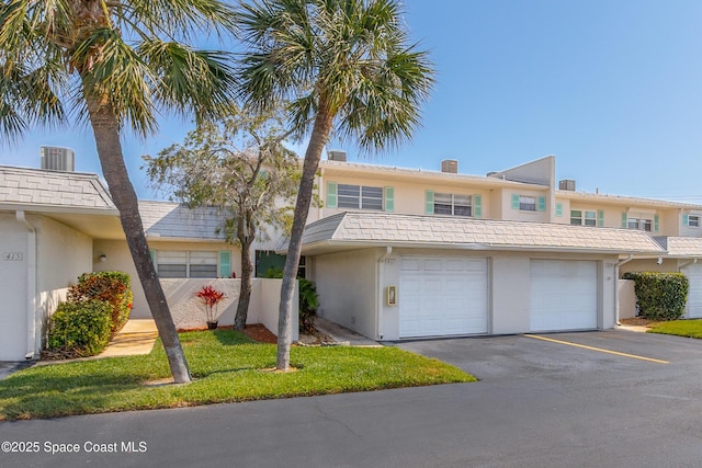 411 Dove Ln Unit 6-11, Satellite Beach, FL 32937 - view of property featuring stucco siding, asphalt driveway, and a garage