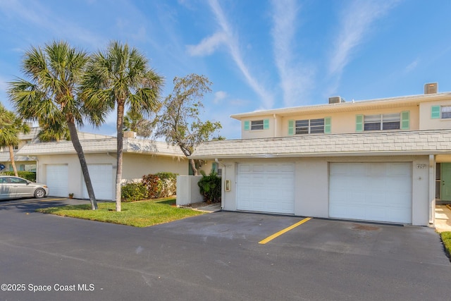 411 Dove Ln Unit 6-11, Satellite Beach, FL 32937 - view of property with stucco siding, a garage, and asphalt driveway