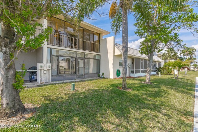 411 Dove Ln Unit 6-11, Satellite Beach, FL 32937 - rear view of property with a sunroom, stucco siding, and a yard