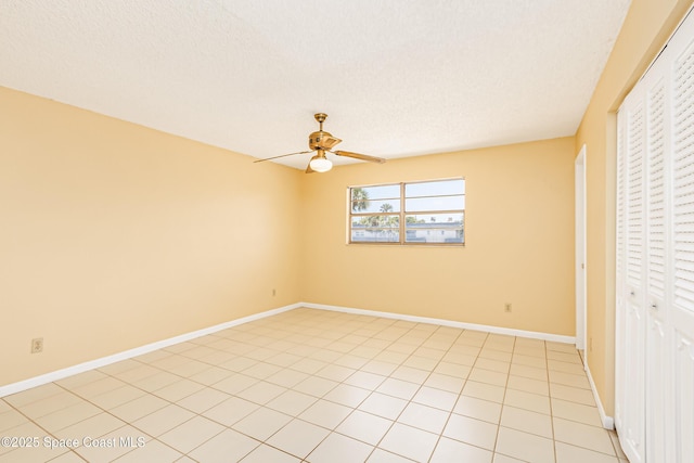 411 Dove Ln Unit 6-11, Satellite Beach, FL 32937 - unfurnished bedroom with a closet, a ceiling fan, baseboards, light tile patterned floors, and a textured ceiling