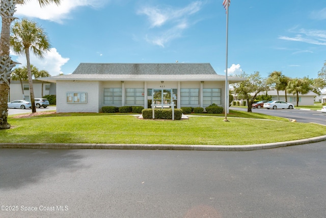 411 Dove Ln Unit 6-11, Satellite Beach, FL 32937 - view of front of house with a front yard, uncovered parking, and roof with shingles