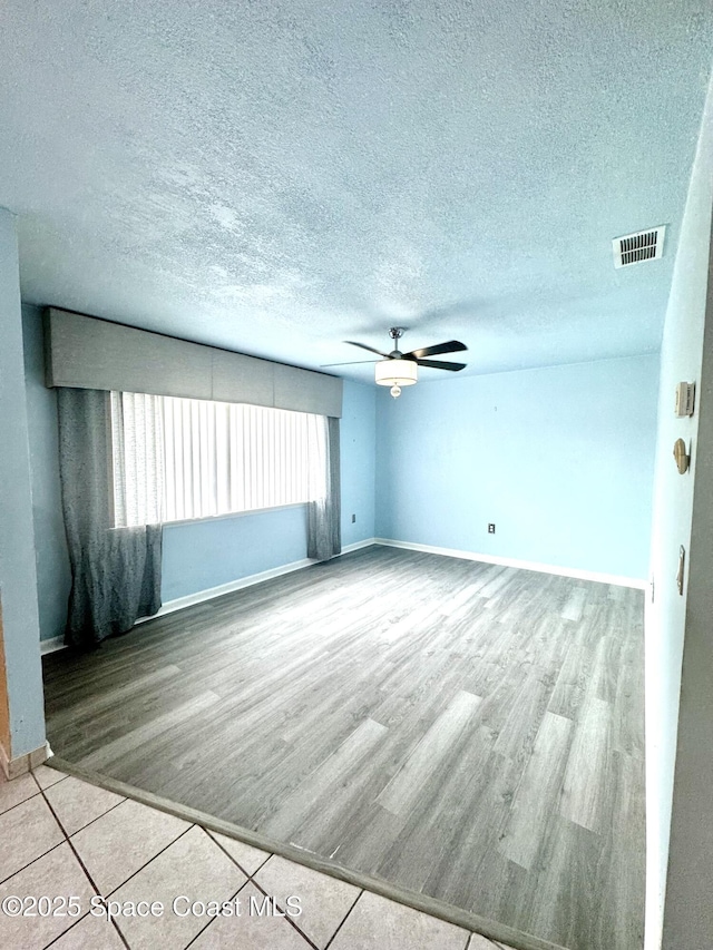 624 Ridge Club Dr Unit 86, Melbourne, FL 32934 - empty room with wood finished floors, a ceiling fan, a textured ceiling, and baseboards