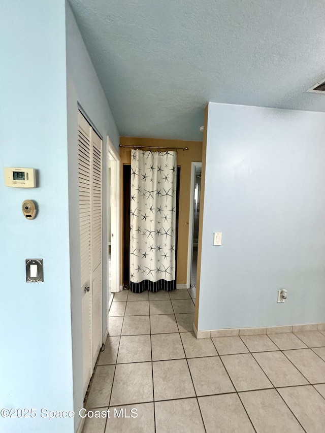 624 Ridge Club Dr Unit 86, Melbourne, FL 32934 - hallway with light tile patterned floors and a textured ceiling