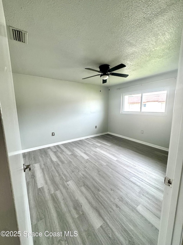 624 Ridge Club Dr Unit 86, Melbourne, FL 32934 - unfurnished room featuring a textured ceiling, ceiling fan, wood finished floors, and baseboards