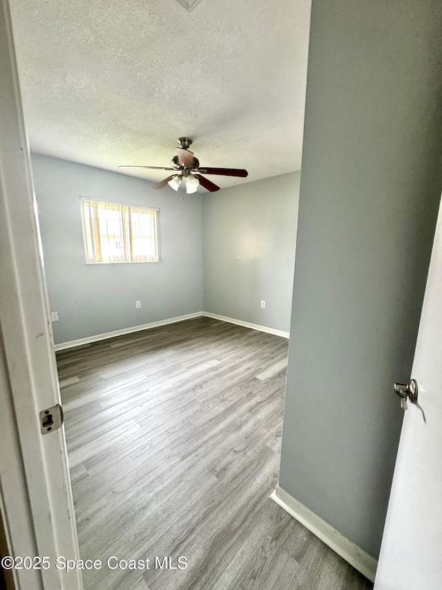 624 Ridge Club Dr Unit 86, Melbourne, FL 32934 - spare room featuring a textured ceiling, ceiling fan, wood finished floors, and baseboards