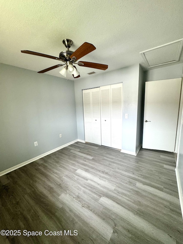 624 Ridge Club Dr Unit 86, Melbourne, FL 32934 - unfurnished bedroom with a closet, a textured ceiling, baseboards, and wood finished floors