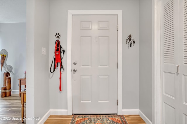 foyer entrance with baseboards and light wood-type flooring