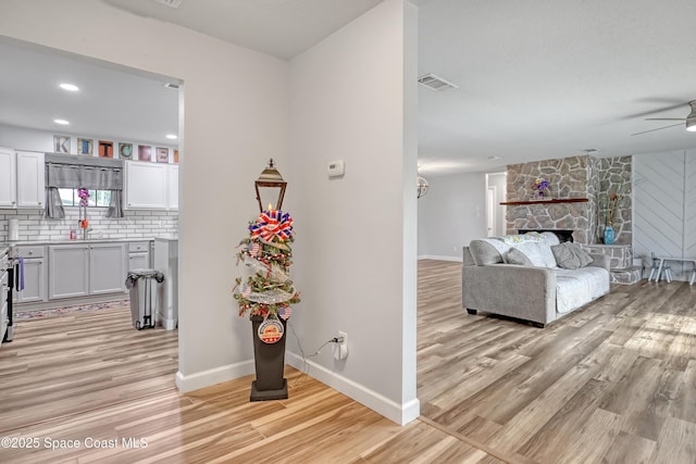 corridor featuring light wood-style flooring and baseboards