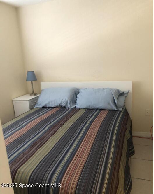 bedroom featuring tile patterned floors and baseboards