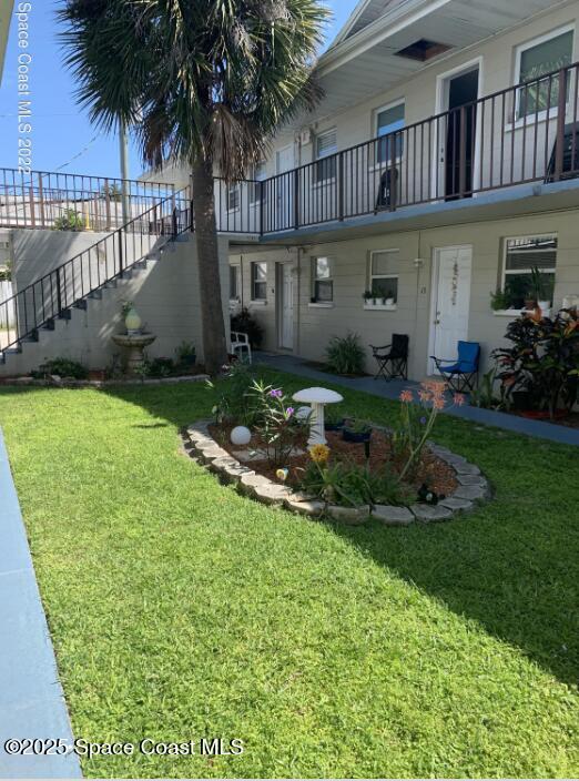 view of grassy yard featuring stairway