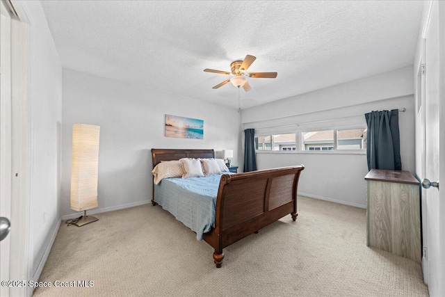 carpeted bedroom featuring baseboards, a textured ceiling, and ceiling fan