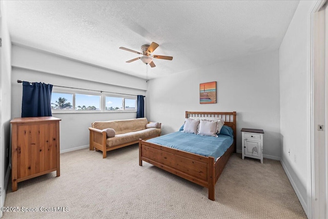 bedroom featuring carpet flooring, a textured ceiling, baseboards, and a ceiling fan