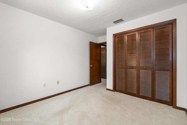 9020 Brighton Ct Unit 4-H, West Melbourne, FL 32904 - unfurnished bedroom with carpet floors, a closet, baseboards, and a textured ceiling