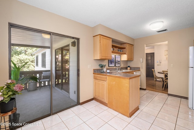 9020 Brighton Ct Unit 4-H, West Melbourne, FL 32904 - kitchen featuring light brown cabinets, freestanding refrigerator, a peninsula, light tile patterned floors, and open shelves