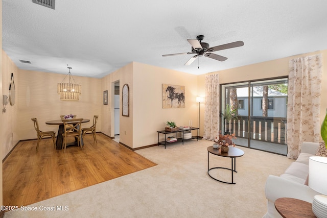 9020 Brighton Ct Unit 4-H, West Melbourne, FL 32904 - carpeted living room with a ceiling fan, baseboards, and a chandelier