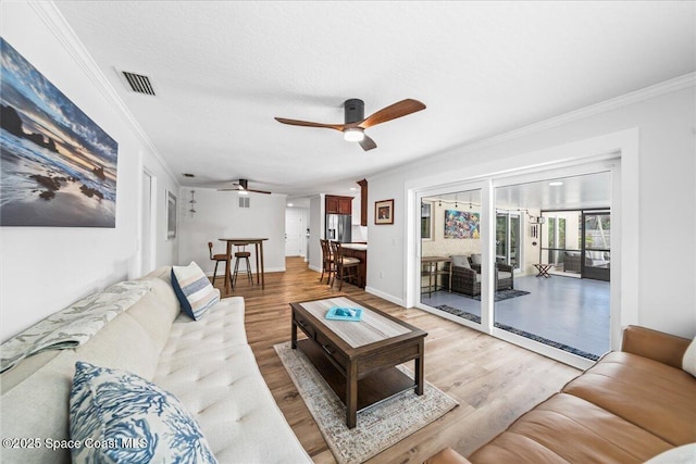 515 Hibiscus Trl, Melbourne Beach, FL 32951 - living area featuring crown molding, ceiling fan, light wood-style floors, and baseboards