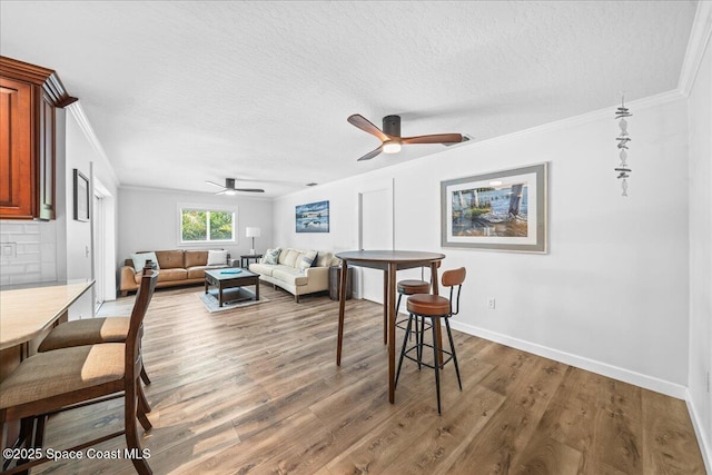 515 Hibiscus Trl, Melbourne Beach, FL 32951 - living area with crown molding, a ceiling fan, wood finished floors, a textured ceiling, and baseboards