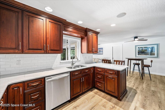 515 Hibiscus Trl, Melbourne Beach, FL 32951 - kitchen with dishwasher, a sink, light wood-type flooring, a peninsula, and decorative backsplash