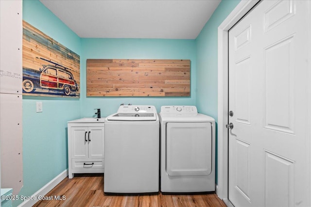 515 Hibiscus Trl, Melbourne Beach, FL 32951 - laundry room featuring cabinet space, light wood-style floors, washing machine and dryer, and baseboards