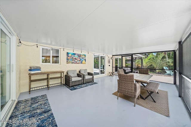 515 Hibiscus Trl, Melbourne Beach, FL 32951 - sunroom featuring finished concrete flooring, healthy amount of natural light, a textured wall, and outdoor dining area