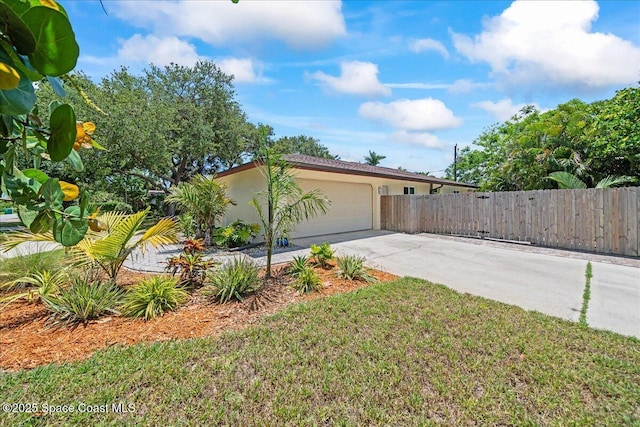 515 Hibiscus Trl, Melbourne Beach, FL 32951 - view of side of property with an attached garage, fence, stucco siding, and driveway