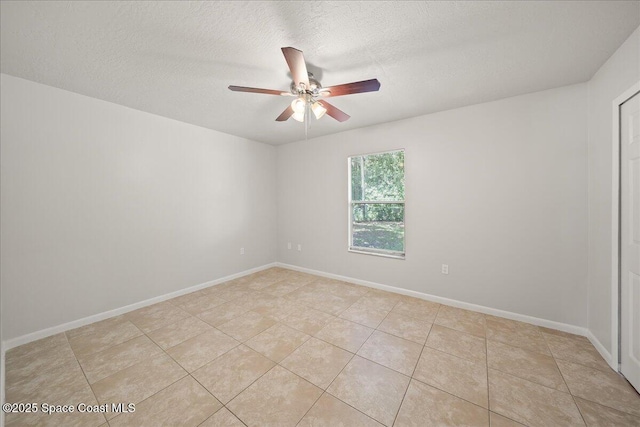 unfurnished room featuring ceiling fan, a textured ceiling, light tile patterned flooring, and baseboards